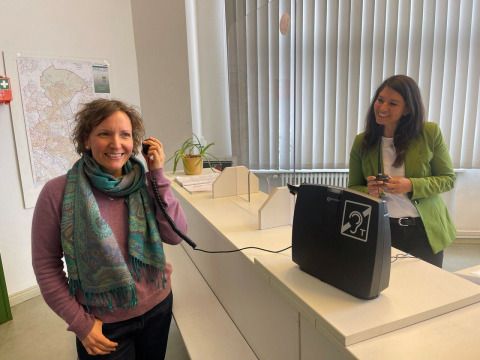 Die Beauftragte für Menschen mit Behinderungen Daniela Kaup und FM-Stadträtin Filiz Keküllüoğlu an der Rathaus-Information mit der neuen Induktionsschleife.