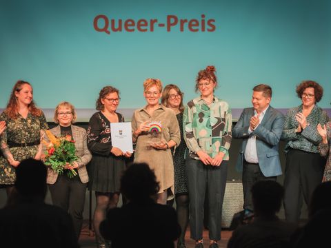 von links nach rechts: Bezirksstadträtin Filiz Keküllüoğlu, Diversity- und Queerbeauftragte Sabine Pöhl, Mitarbeitende des VaV e.V., Geschäftsführerin des VaV e.V., Bezirksbürgermeister Martin Schaefer, die Bezirksstadträtin Camilla Schuler, Bezirksstadträtin Sandy Mattes und Gregor Hoffmann, Vorsteher der BVV Lichtenberg bei der Übergabe des Queer Preises Lichtenberg 2026 (Bild: Bezirksamt Lichtenberg)