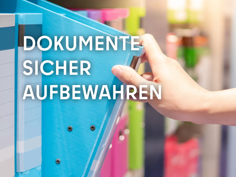 Eine Hand greift zum Aktenordner mit Unterlagen