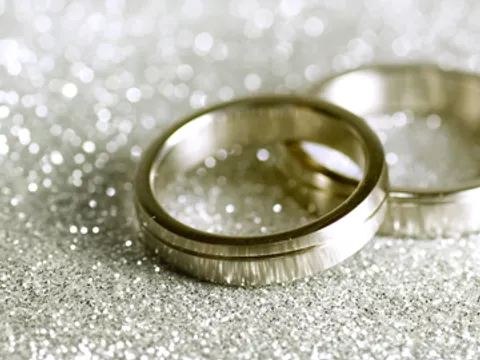 Zwei goldene Ringe auf glitzernen Untergrund