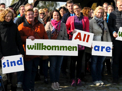Menschengruppe hält Schildmit Beschriftungen
