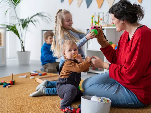 Kinder lernen und spielen mit Erzieherin