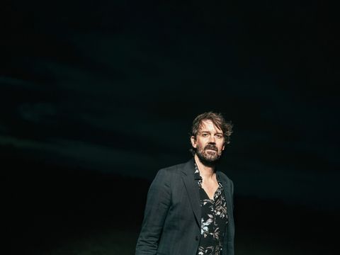 Das Farbfoto zeigt den Musiker Niels Frevert frontal vor schwarzem Hintergrund.