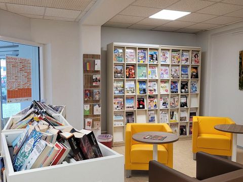 Foyer und Zeitschriften-Regal mit bunten Sesseln und Büchertrödel