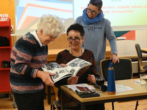 Reihe "Schwebende Bücher" Das Foto zeigt Bibliothekarinnen im Gespräch mit einer Besucherin.