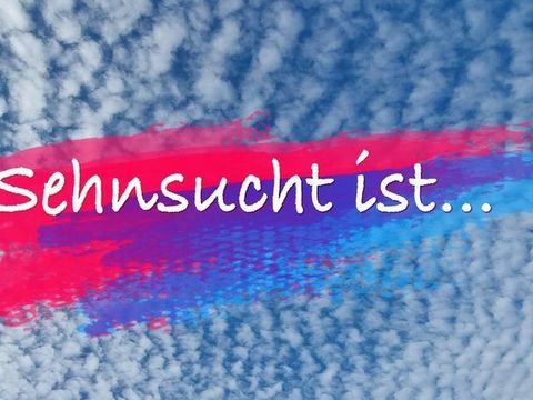 Vor einem beluen Himmel mit weißen Altocummuulswolken schweben pinke und blaue ineinande übergehende Pinselstriche , auf denen in weiß der Schriftzug "Sehnsucht ist..." steht