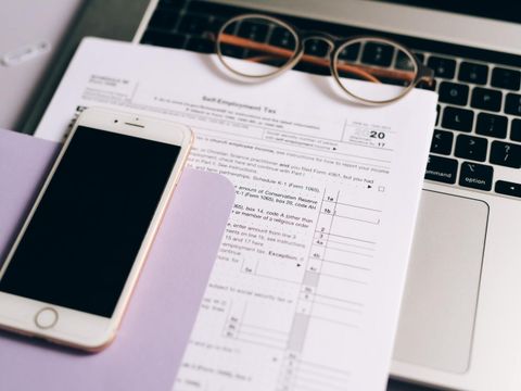 Formulare und Handy auf einem Laptop