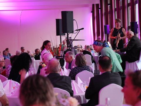 Der gefüllte Saal mit musikalischer Untermahlung.