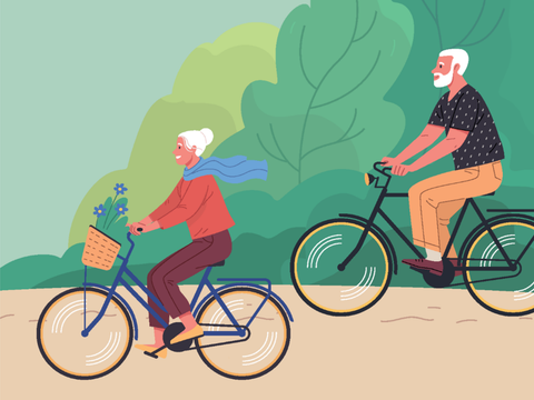 Ältere Frau und älterer Mann fahren mit dem Fahrrad durch eine Grünanlage