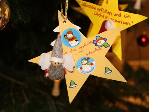 Kinder aus Pflege- und Betreuungseinrichtungen haben ihre Weihnachtswünswche in Sternform gebastelt und hängen diese jetzt an denNeuköllner Wunschbaum im Rathaus.