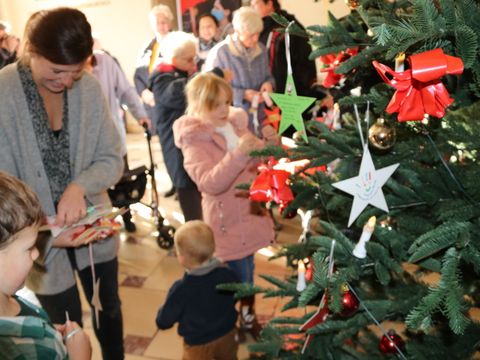Der Wunschbaum wird mit den Sternen von Kindern und Senioren geschmückt.