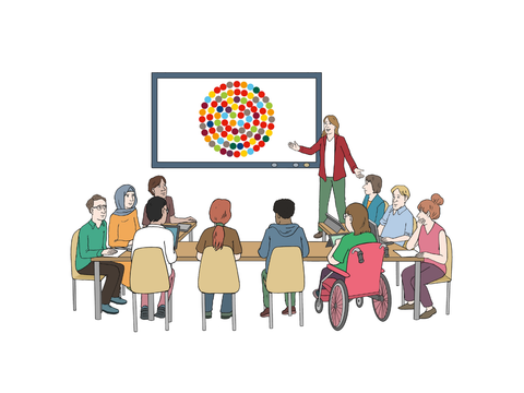 Mehrere Menschen an einem Tisch schauen auf eine Präsentation an der Wand