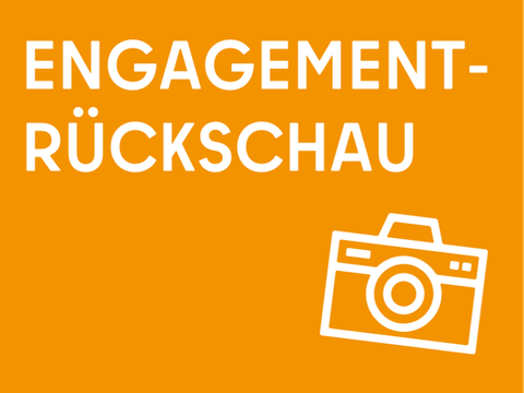 Auf orangenem Hintergrund steht in weißer Schrift "Engagement-Rückschau", darunter rechts ist ebenfalls in weiß ein Kamera-Icon zu sehen.