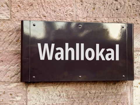 Schild Wahllokal an einer Wand
