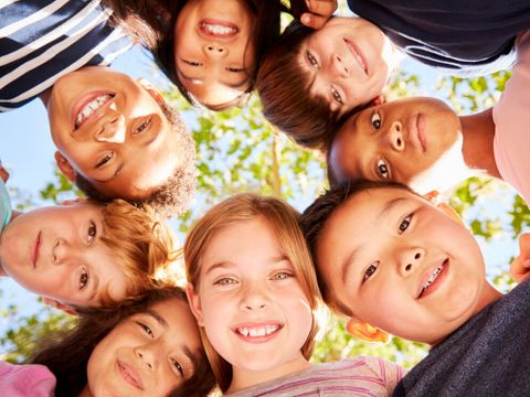 Group of kids outdoors looking down at camera,verticle