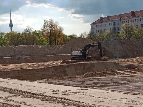 Baugrube mit Bagger und Berliner Fernsehturm im Hintergrund