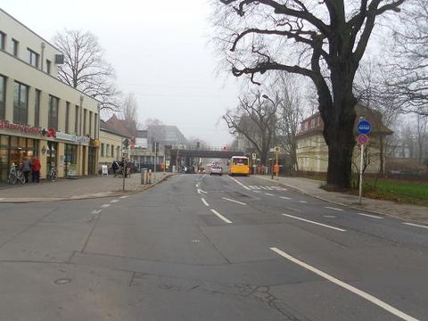 Blick auf die Wiltbergstraße. Im Hintergrund befinden sich der S-Bahnhof und die Bahnbrücke.