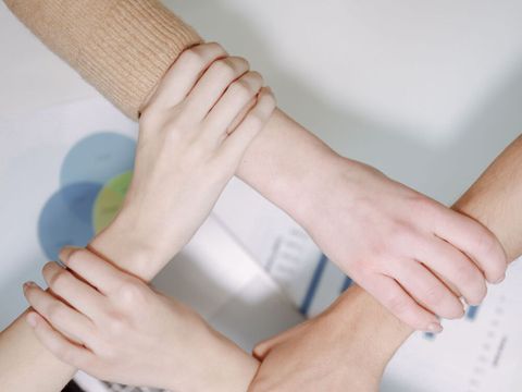 vier Hände halten einander Fest