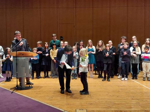 Bezirksbürgermeister Uwe Brockhausen (SPD) übergibt Urkunden und Rosen an die Teilnehmerinnen und Teilnehmer des Regionalwettbewerbs. (Bild: Musikschule Reinickendorf)