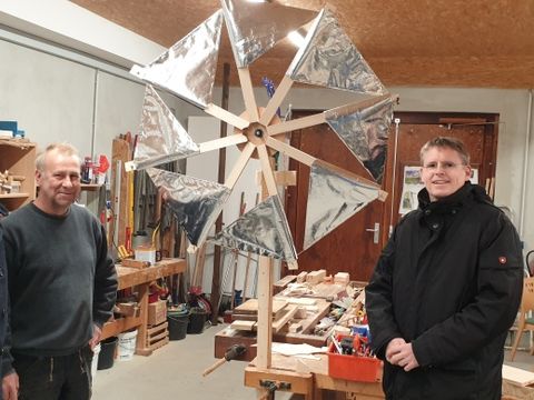 Bezirksstadtrat Tobias Dollase (rechts) mit Geschäftsführer Helmut Wegner und Friedrich Hoffmann in der Werkstatt vor dem von Schülerinnen und Schülern gebauten stromerzeugenden Windrad. (Bild: BA Reinickendorf)
