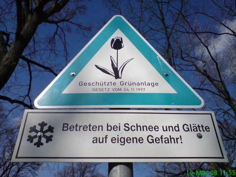 Schild geschützte Grünanlage, darunter Betreten bei Schnee und Glätte auf eigenen Gefahr!