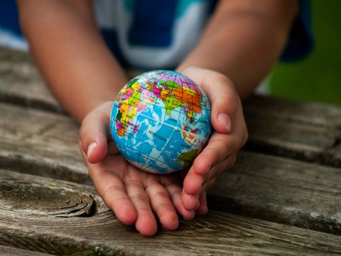 Kinderhände, die eine Weltkugel halten