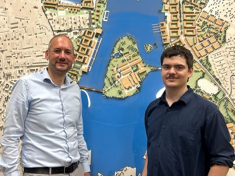 Sargon Lang und Marco Röhberg stehen vor einem Modell Spandaus