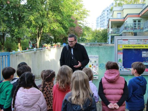 Bezirksstadtrat Urban Aykal spricht mit Kindern der Grundschule an der Bäke über den Bienenfutterautomaten (Bild: Bezirksamt Steglitz-Zehlendorf)