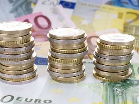 3 Stapel Geldmünzen auf Geldscheinen
