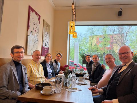20. April 2026: Nachbesprechung in entspannter Atmosphäre: drei Musiker aus Charkiw zusammen mit Dr. Yuri Ilinov (1.v.l.), dem stellv. Bezirksbürgermeister Tim Richter (1.v.r.), dem stellv. Vorsitzenden des Partnerschaftsvereins Rolf Breidenbach (2.v.r.), Vereinsvorstandsmitglied Olga Pischel (3.v.l.) und dem Partnerschaftsbeauftragten des Bezirksamts Christan Urlaub (2.v.l.)
