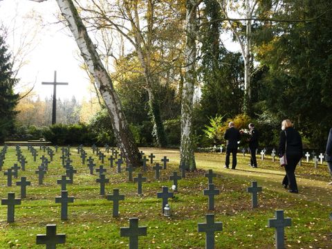 Grabkreuze der Einzelgräber auf dem Heidefriedhof, im Hintergrund das Gedächtniskreuz