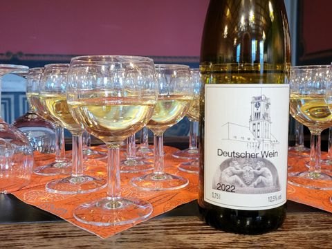 Weingläser gefüllt mit Wein und daneben eine Flasche Wein