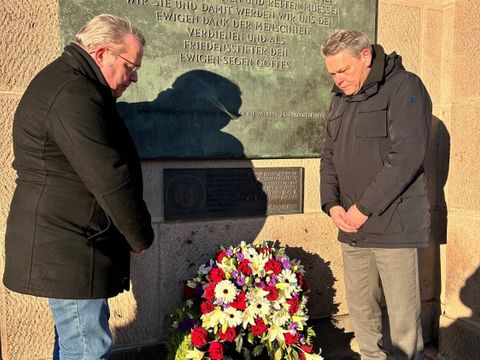 Von links nach rechts: BVV-Vorsteher Stefan Böltes und Bezirksbürgermeister Jörn Oltmann legten einen Kranz vor der Kennedy-Gedenktafel am Rathaus Schöneberg nieder.