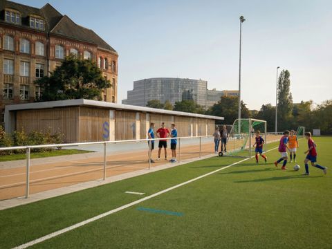 Kinder kicken auf einem Fußballplatz den Ball
