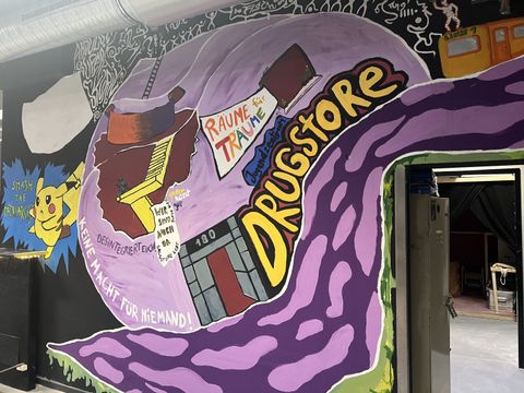 An der Wand ist eine Kunstwerkgezeichnet, worauf Jugendzentrum Drugstore steht.