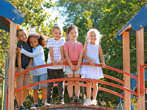 Kinder stehen auf einem Brückenelement vom Spielplatz