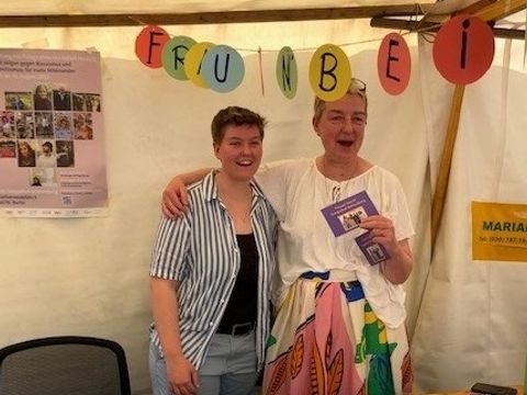 Zwei Frauen hinter einem Marktstand mit Informationsmaterial