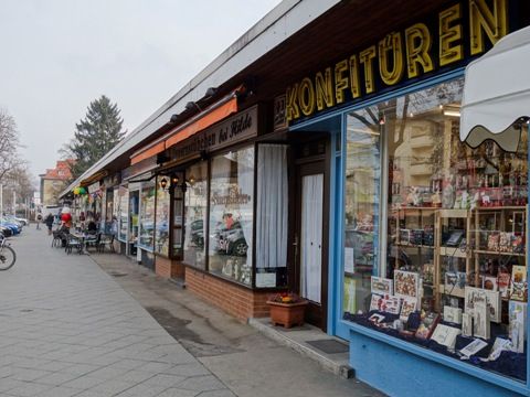 Fotografie einer Ladenzeile in der Bahnhofstraße in Lichtenrade mit Fokus auf einem Schaufenster eines Konfitürengeschäfts