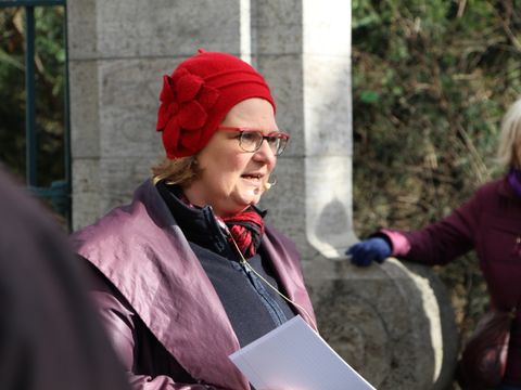Auf dem Viktoria-Luise-Platz trotzen Bezirksbürgermeisterin Angelika Schöttler und die Teilnehmenden Wind und Wetter.