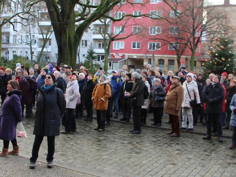 Die Teilnehmenden schauen zum Turm der Nathanaelkirche, die nach dem 2. Weltkrieg teilweise wiederaufgebaut werden musste.