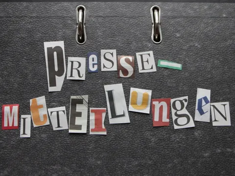ausgeschnittene Zeitungsbuchtagen bilden das Wort Pressemitteilungen