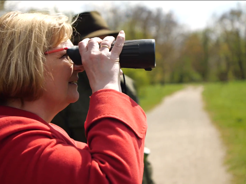 Frau schaut durch ein Fernglas