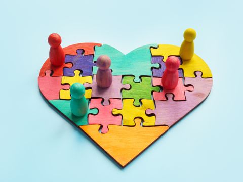 Herz aus Puzzleteilen mit Spielfiguren