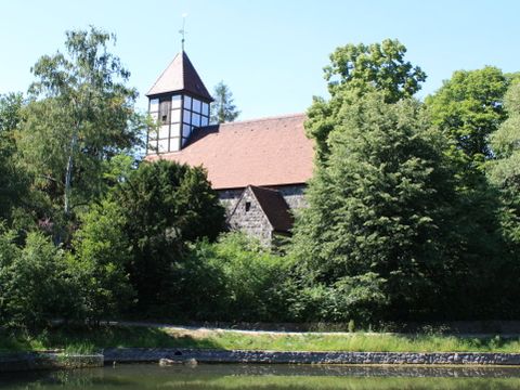 Ansicht der Dorfkirche Tempelhof durch die Bäume hindurch