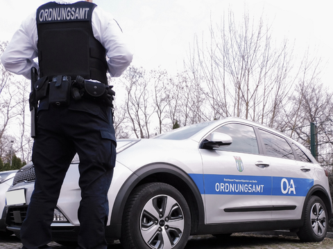 Dienstkraft des Allgemeinen Ordnungsdienstes mit Dienstfahrzeug