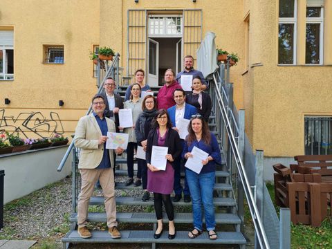 Staatssekretär für Soziales, Aziz Bozkurt, der Bezirksbürgermeister Oliver Igel, die Bezirksstadträtin für Soziales, Gesundheit, Arbeit und Teilhabe, Carolin Weingart sowie Vertreterinnen und Vertreter von Rabenhaus e.V., Offensiv‘91 e.V., der Technische Jugendfreizeit- und Bildungsgesellschaft gGmbH, der KungerKiezInitiative e.V. und ajb gmbH mit der unterzeichneten Kooperation