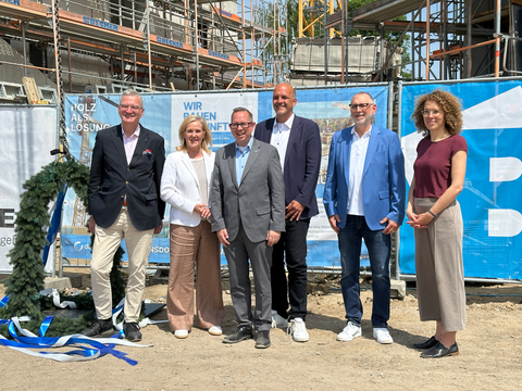 Personengruppe neben einem Richtkranz auf einer Baustelle