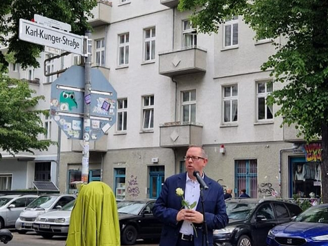 Bezirksbürgermeister Igel vor Straßenschild Karl-Kunger-Straße