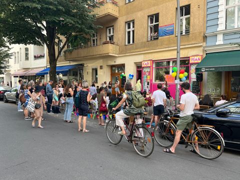 Viele Menschen stehen vor dem geschmückten Café Pink