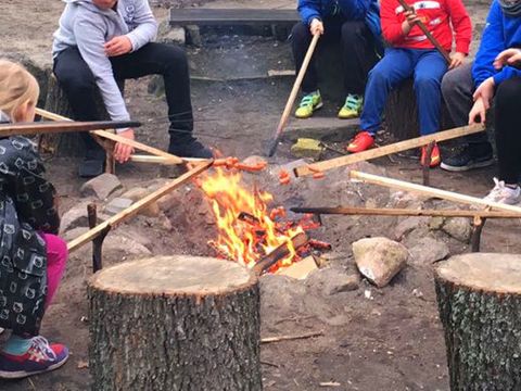 Kinder halten Stöcke in ein Lagerfeuer